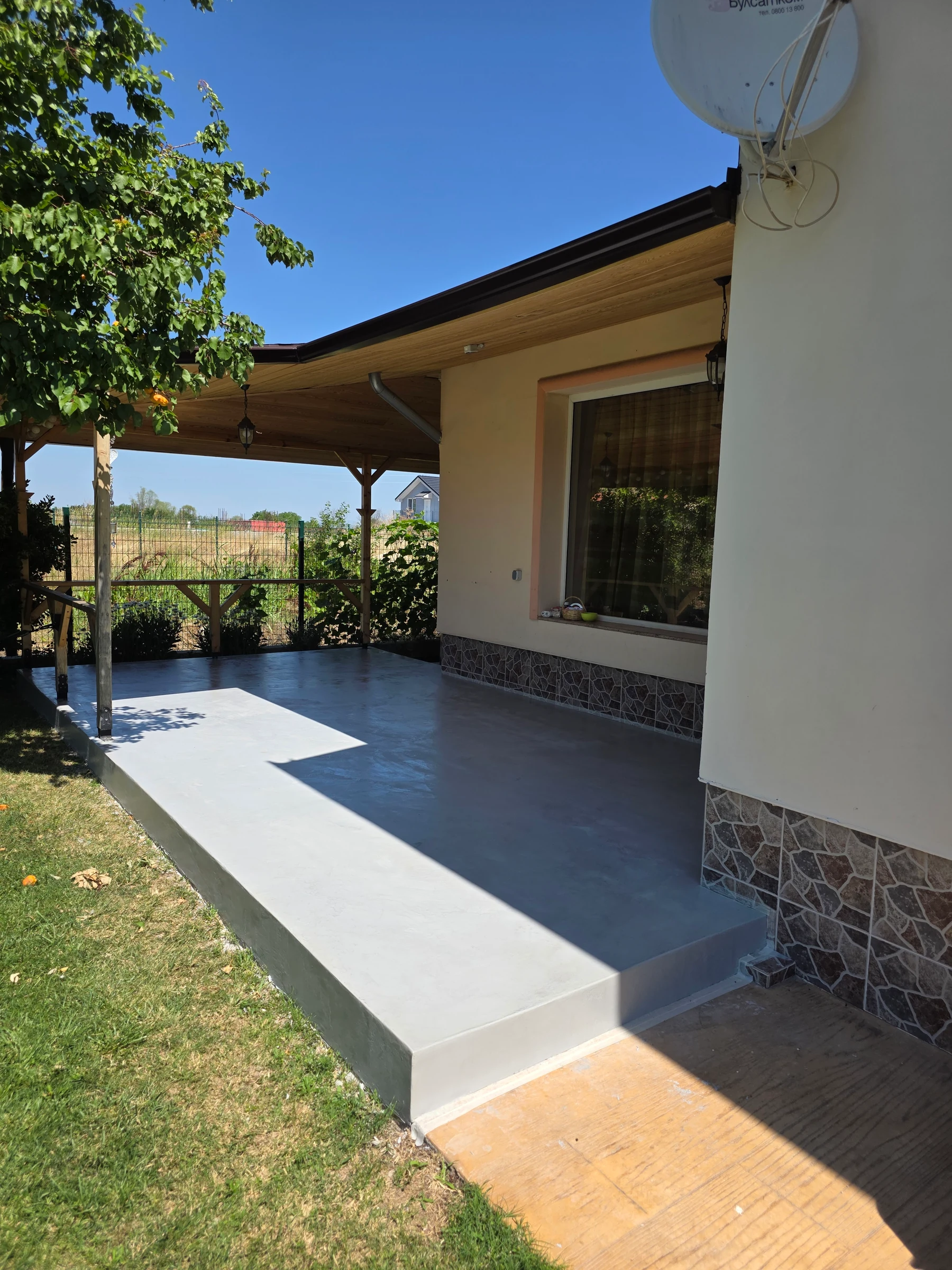 Side view of the veranda with the new floor finish and stone-clad wall base.