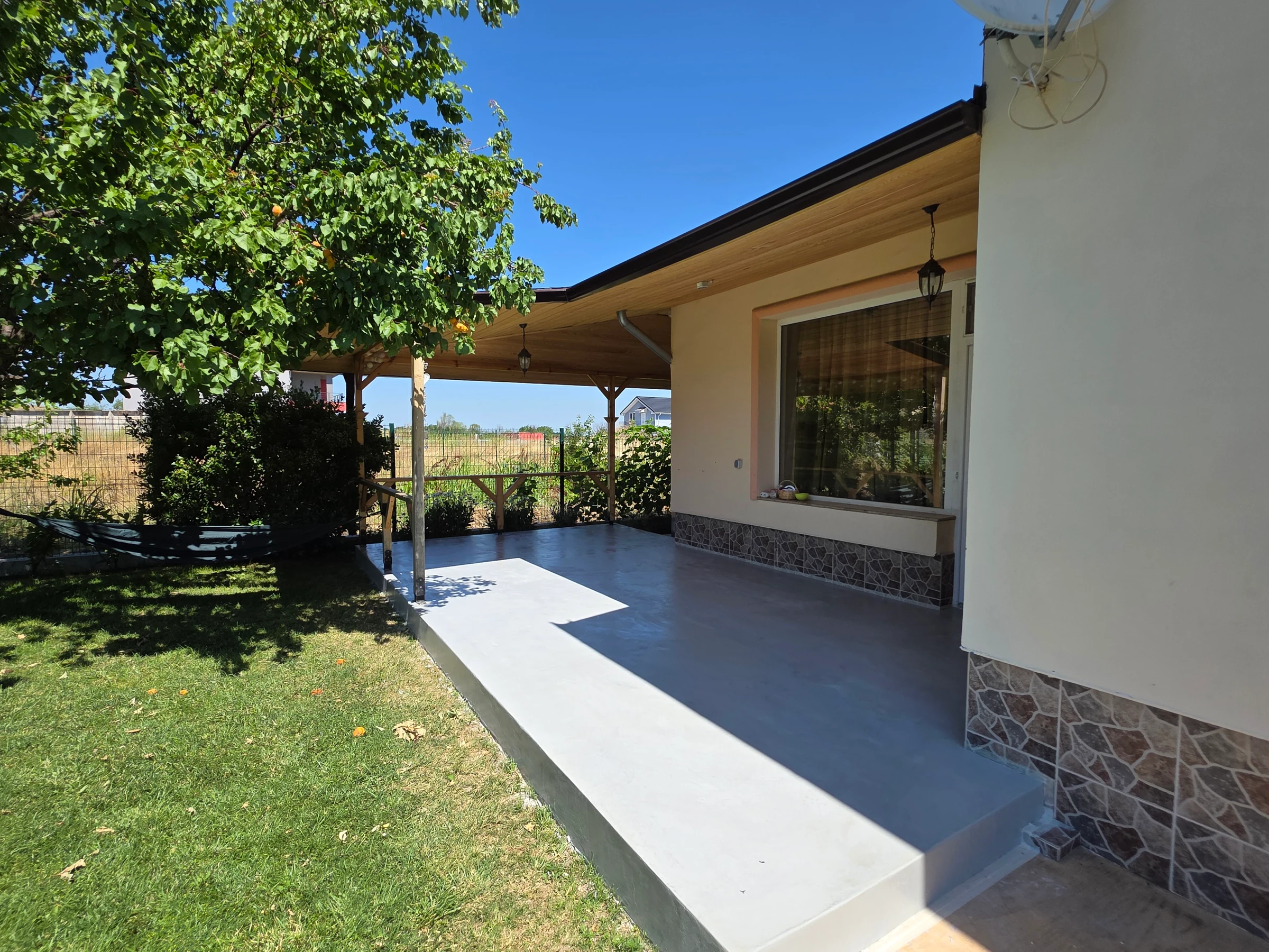 Garden-side view of the covered veranda and its light-grey floor.